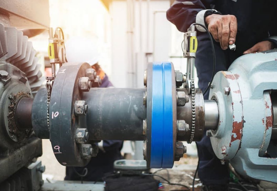 Close-up of industrial shaft and machinery alignment work