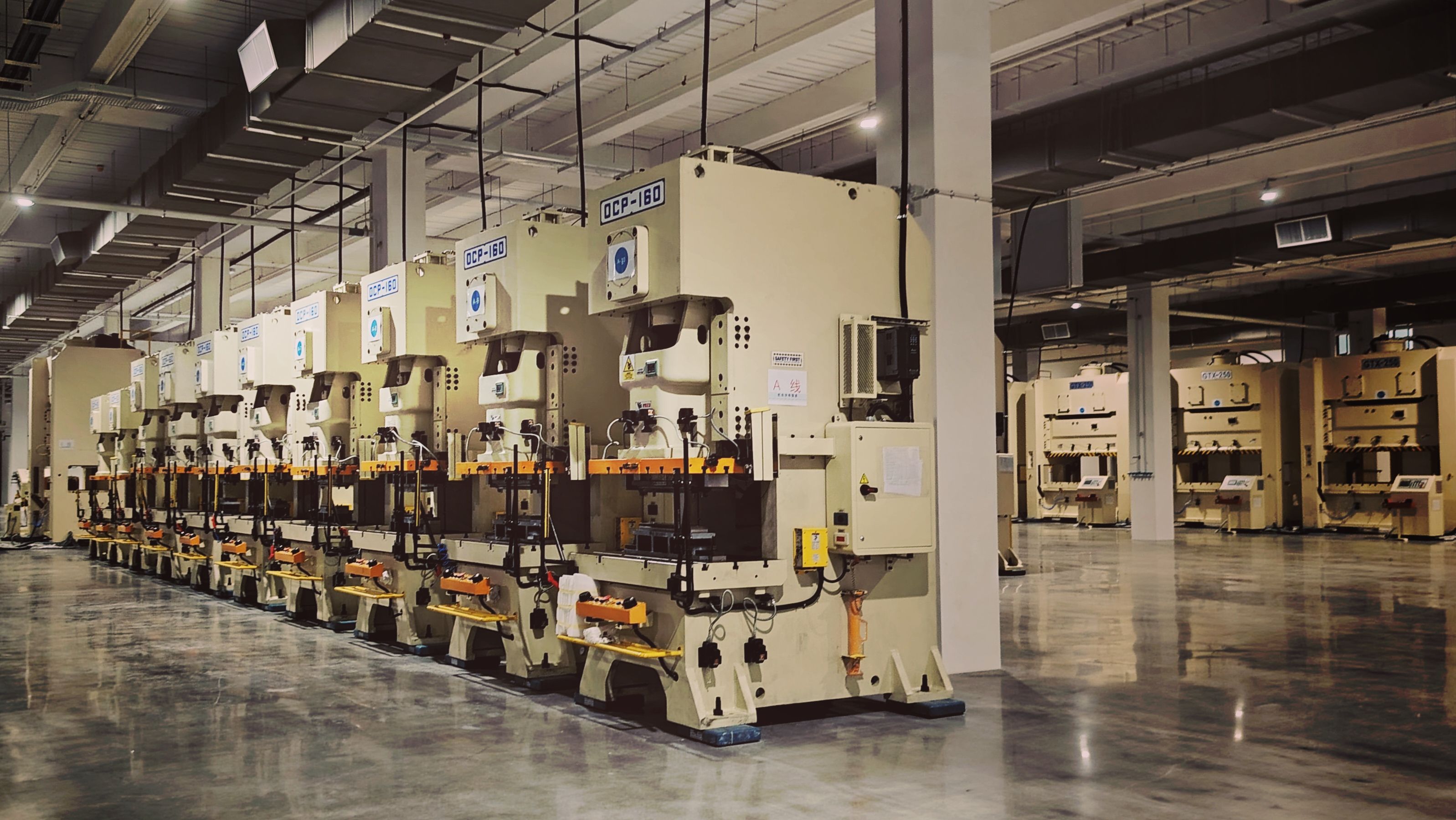 Row of industrial stamping machines on a factory floor