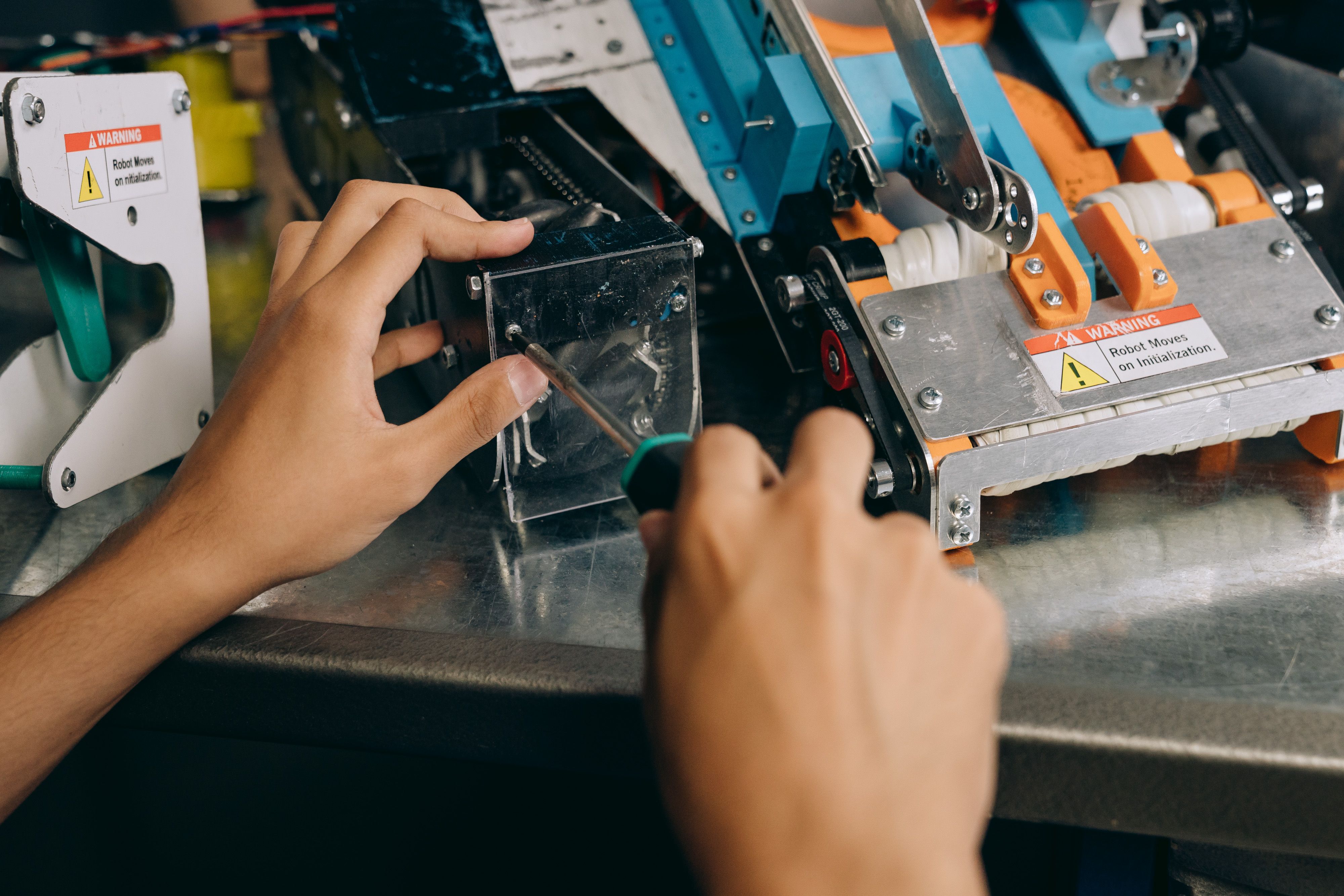 Technician using precision tools to repair robotic machinery